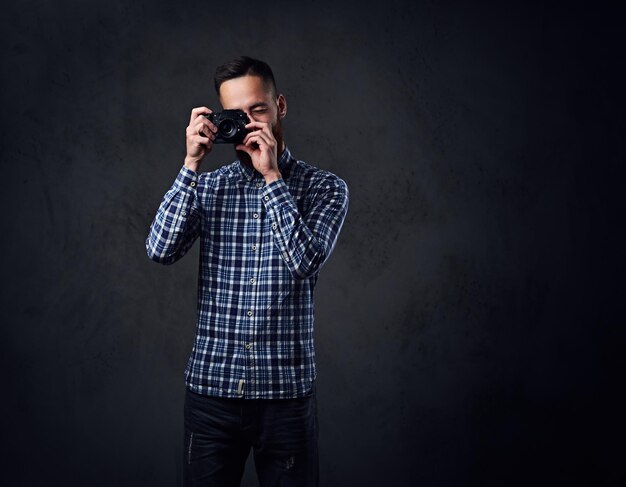 Roodharige, bebaarde man gekleed in een blauw fleece-shirt dat foto's maakt met een compactcamera.