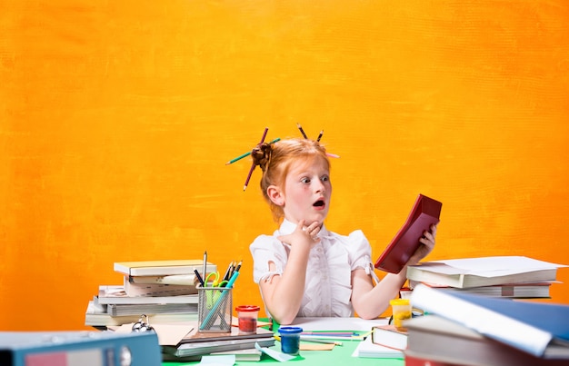 Gratis foto roodharige tiener meisje met veel boeken thuis