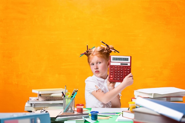 Roodharige tienermeisje met veel boeken thuis. schot