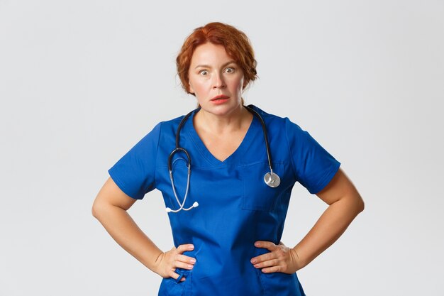 Roodharige verpleegster op middelbare leeftijd poseren