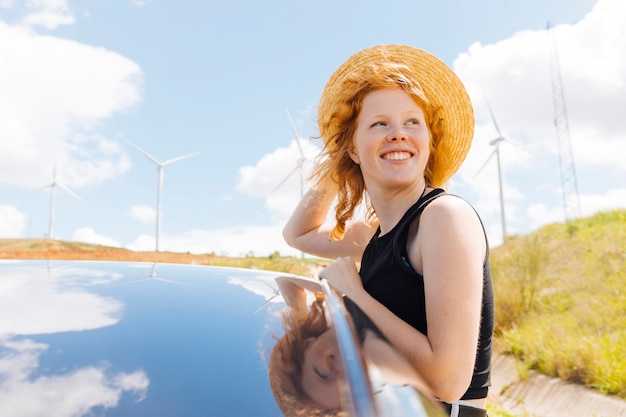 Gratis foto roodharige vrouw die van wind in aard geniet