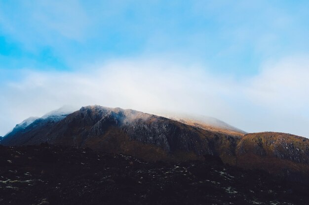 Rookwolk die uit een bergachtig landschap komt dat de hemel raakt