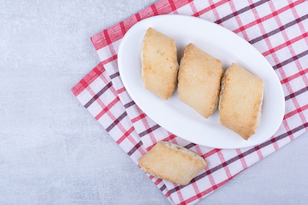 Room gevulde koekjes op witte plaat.