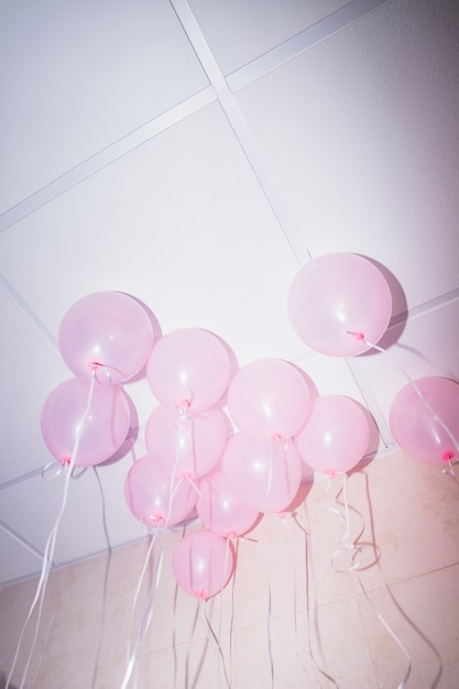 Roze ballonnen drijvend op het plafond van een feestje
