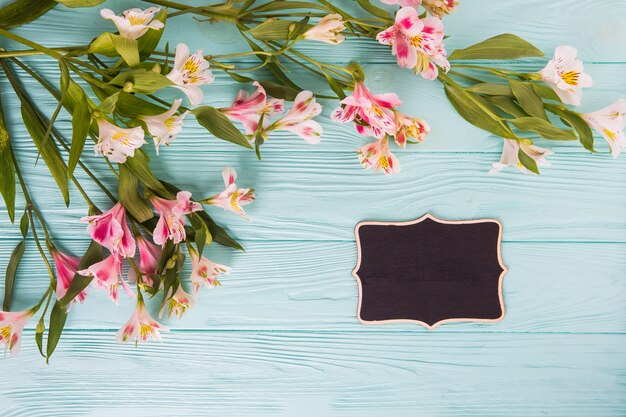 Roze bloemen met kleine schoolbord op tafel