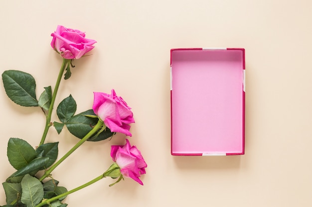 Roze bloemen met lege doos op tafel