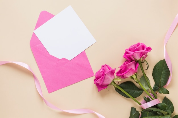 Roze bloemen met papier in de envelop