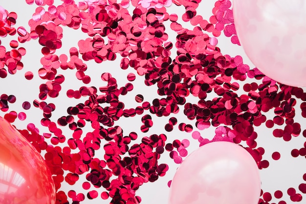Gratis foto roze confetti en ballonnen in lay-out