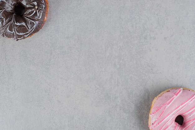 Roze en chocolade donuts op een betonnen ondergrond