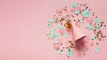 Gratis foto roze feestmuts omringd door confetti en papier