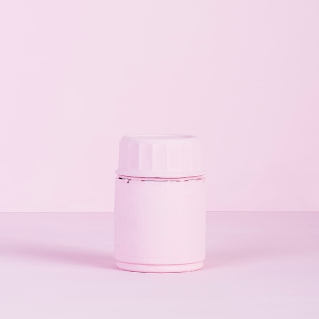 Roze gesloten fles op roze achtergrond