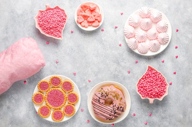 Roze kleurensnoepjes, snoepjes, meringue en suiker.