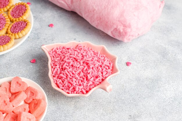 Roze kleurensnoepjes, snoepjes, meringue en suiker.