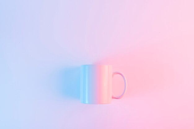 Roze koffiemok tegen roze achtergrond met copyspace voor het schrijven van de tekst
