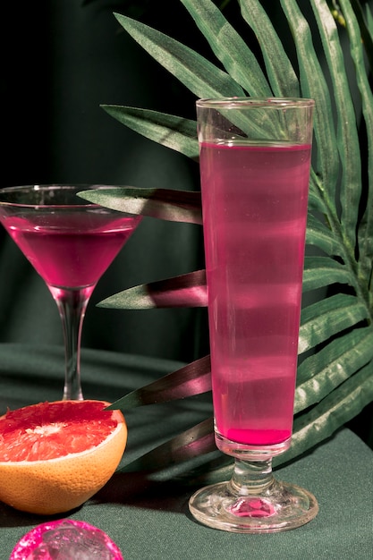 Gratis foto roze martini naast tropische plant