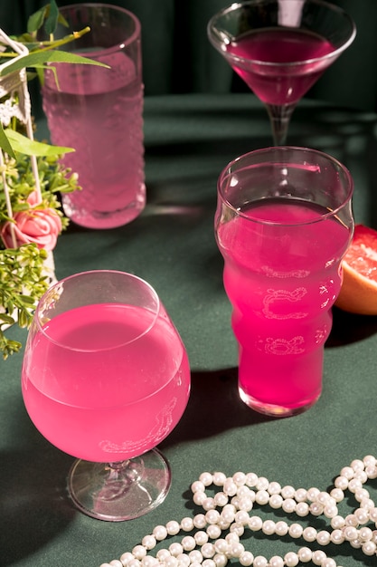 Gratis foto roze martini's naast parels op tafel