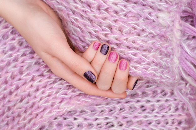 Roze nagelontwerp. Vrouwelijke handen met glitter manicure.