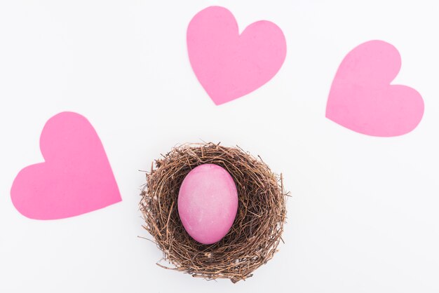 Roze paasei in nest op tafel