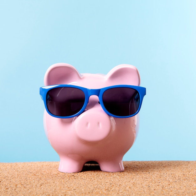 Roze spaarvarken strand reizen vakantie besparingen zonnebril.