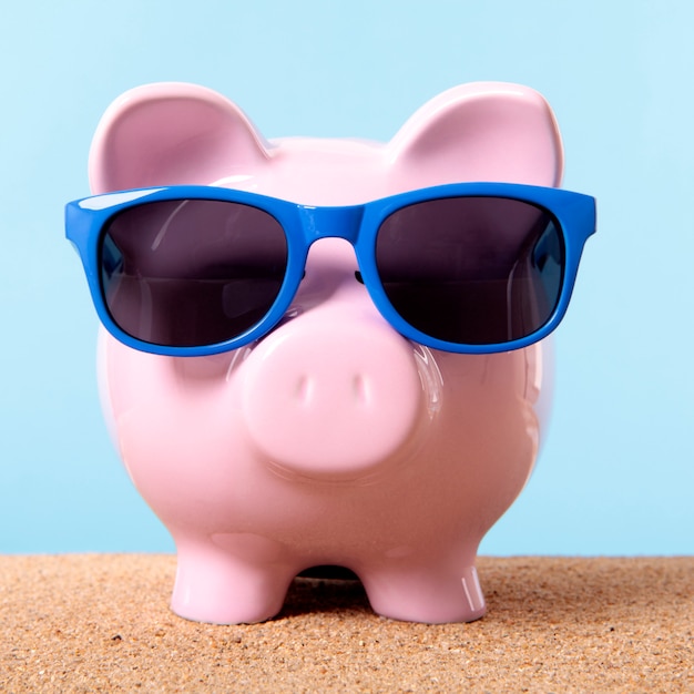 Roze spaarvarken strand reizen vakantie besparingen zonnebril.