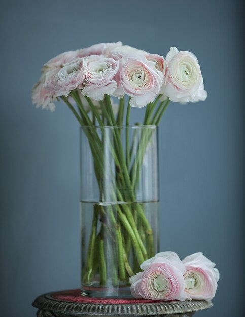 roze witte bloemen in de fles op de tafel