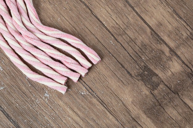 Gratis foto roze witte spiraalvormige jellybeans op een houten bord.