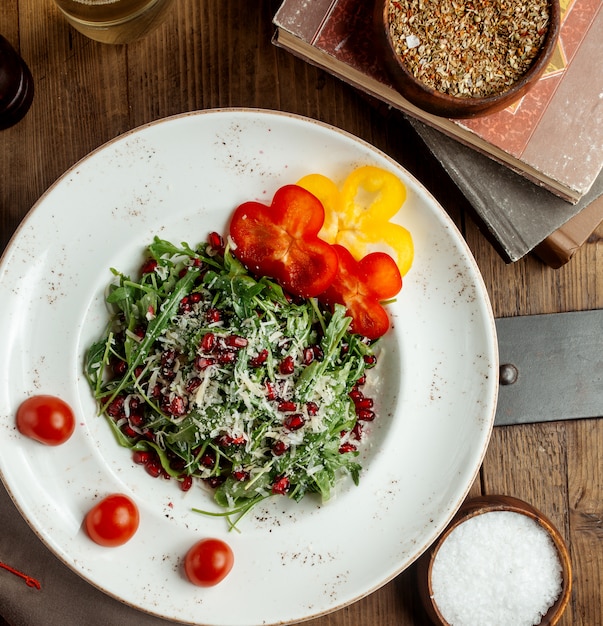 Rucola salade gegarneerd met Parmezaanse granaatappel paprika en cherrytomaat