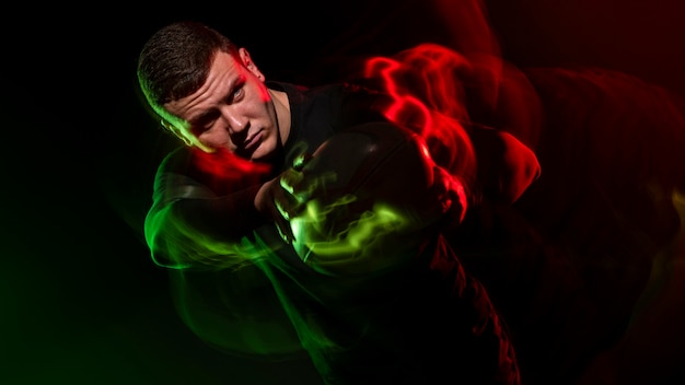 Gratis foto rugbyspeler met bal met kleureffect