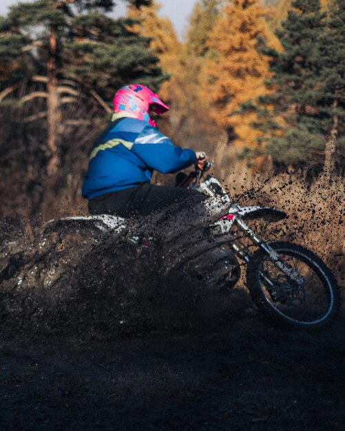 Ruiter op een motor rijden in het bos op een zonnige dag