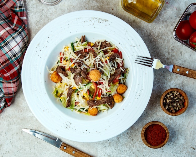 Rundersalade met kipballetjes, sla, geraspte kaas, maïs en paprika