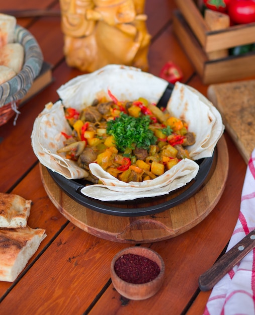 Gratis foto rundvlees stoofpot met aardappelen en gehakte groenten geserveerd met lavash.