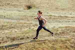 Gratis foto running sport. man runner sprinten buiten in de schilderachtige natuur. fit gespierde mannelijke atleet training parcours uitgevoerd voor marathon run.