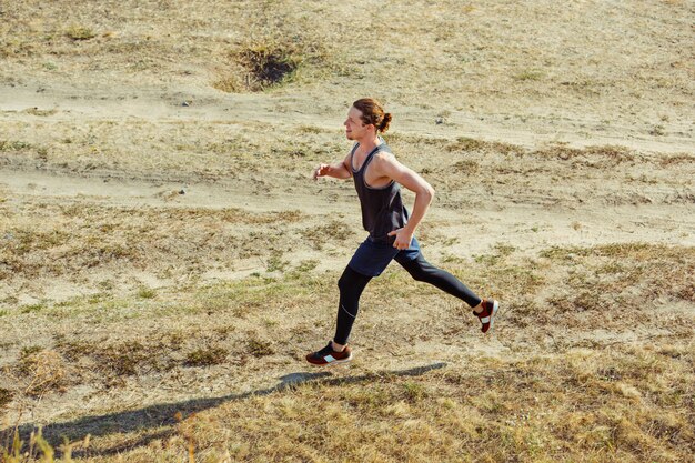 Running sport. Man runner sprinten buiten in de schilderachtige natuur. Fit gespierde mannelijke atleet training parcours uitgevoerd voor marathon run.