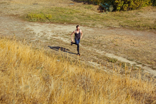 Running sport. Man runner sprinten buiten in de schilderachtige natuur. Fit gespierde mannelijke atleet training parcours uitgevoerd voor marathon run.