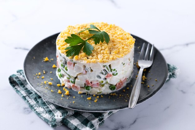 Russische salade of Olivier salade op marmeren tafel voor het kerstdiner