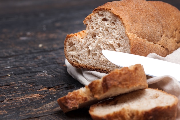 Rustiek brood op houten tafel. Donker houtachtig met vrije tekstruimte.