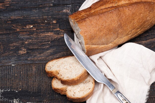 Rustiek brood op houten tafel. Donkere bosrijke ruimte met vrije tekstruimte.