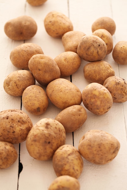 Gratis foto rustieke ongeschilde aardappelen op een tafel