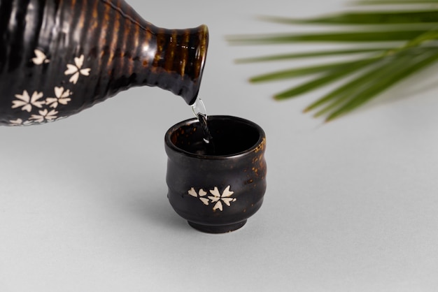 Gratis foto sake-drank in kopje stilleven hoge hoek gieten