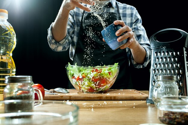 Salade bereiden. Vrouwelijke chef-kok die verse groenten snijdt.