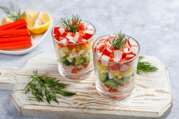 Salade met krabsticks, eieren, maïs en komkommer.
