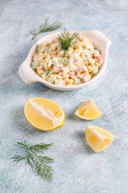 Salade met krabsticks, eieren, maïs en komkommer.