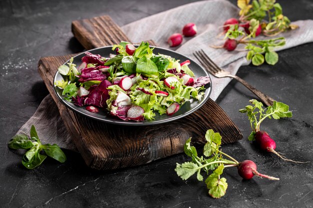 Salade met verschillende ingrediënten op donkere plaat