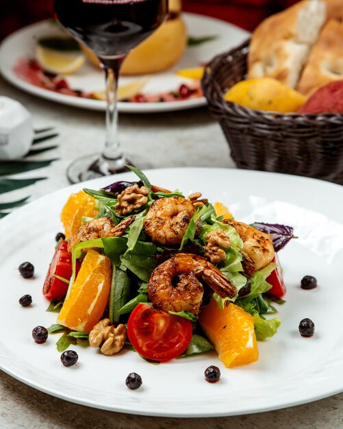 Salade van gebakken garnalen met sla, rucola, sinaasappel, tomaten, walnoot en donkere opaal basilicum