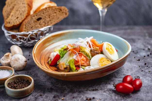 Salade van gerookte zalm met gekookte ei, tomatensla, champignon ui