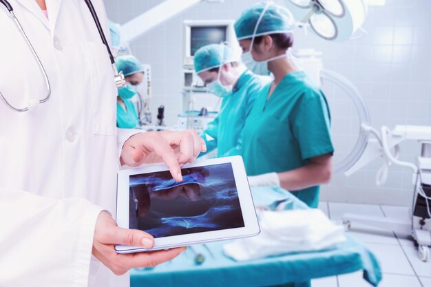 Samengesteld beeld van arts die xray op tablet bekijkt Premium Foto