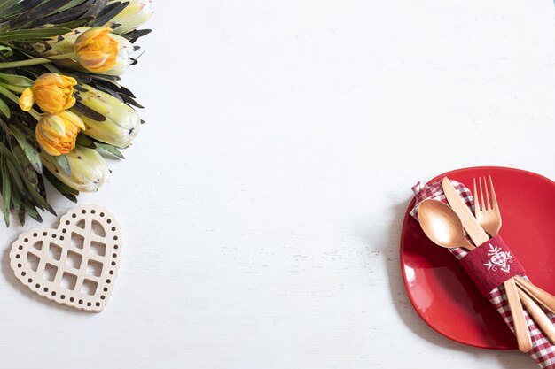 Samenstelling met een bord en bestek voor een romantisch diner en decoratieve elementen Valentijnsdag bovenaanzicht. Dating concept.
