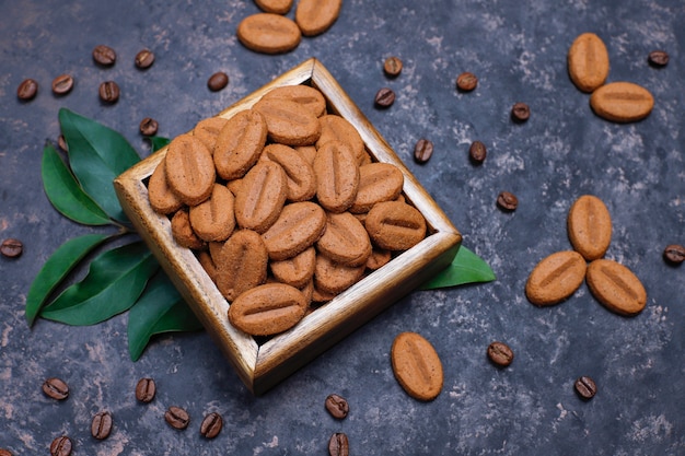 Samenstelling met geroosterde koffiebonen en koffieboonvormige koekjes op donkere bruine oppervlakte