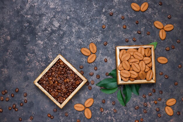 Samenstelling met geroosterde koffiebonen en koffieboonvormige koekjes op donkere bruine oppervlakte