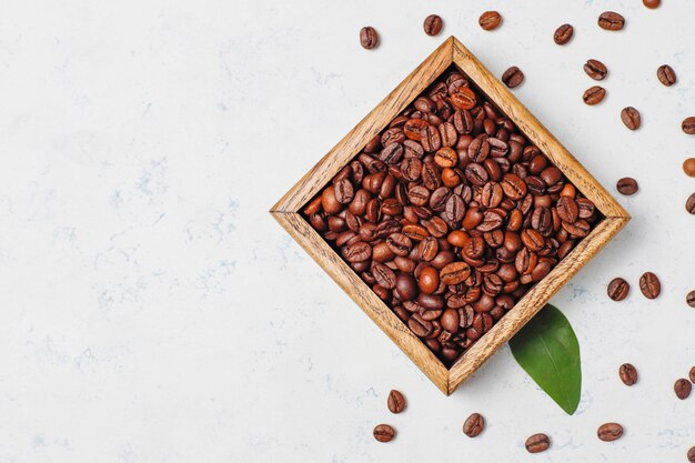 Samenstelling met geroosterde koffiebonen en koffieboonvormige koekjes op lichte oppervlakte